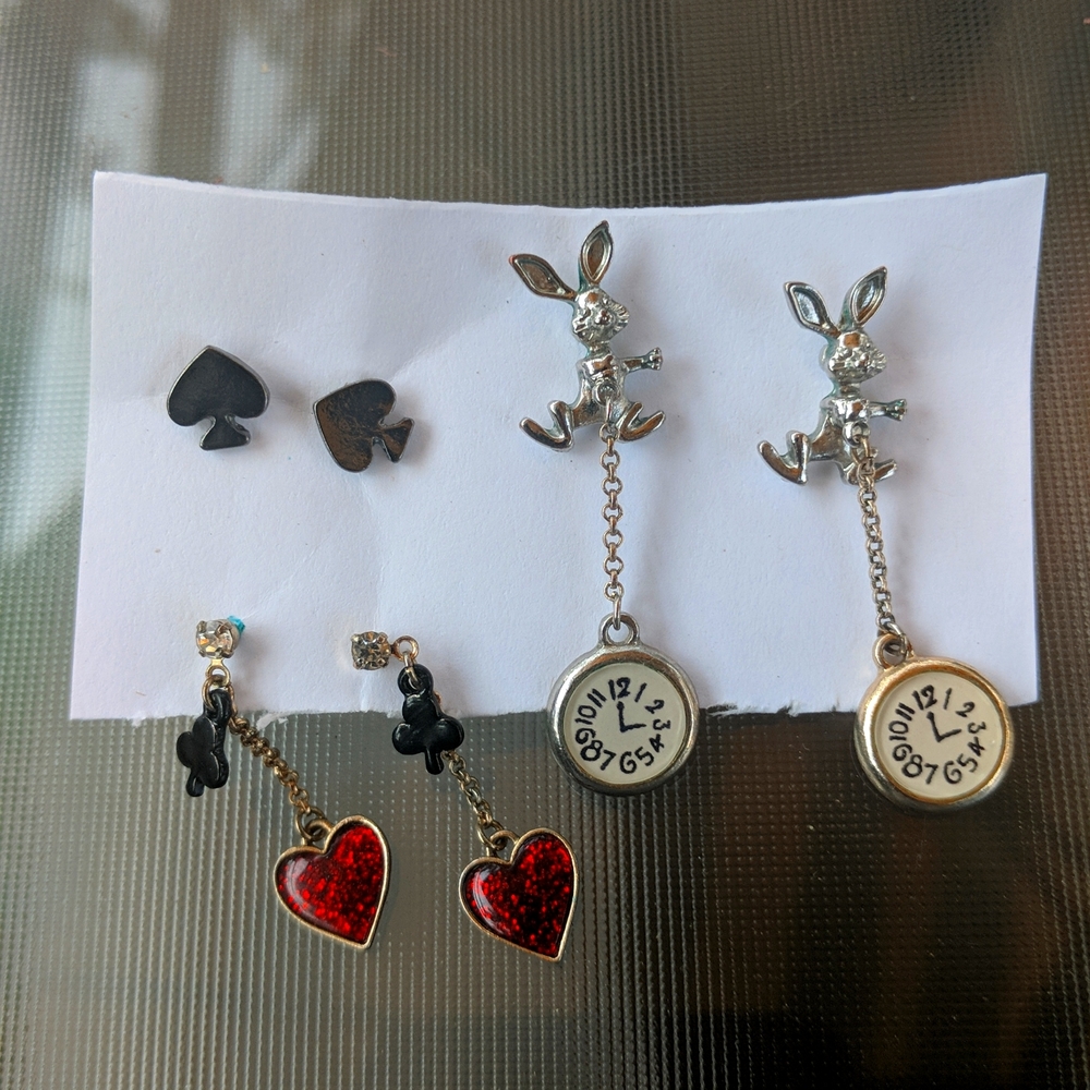 Three pairs of Alice in wonderland style earrings.